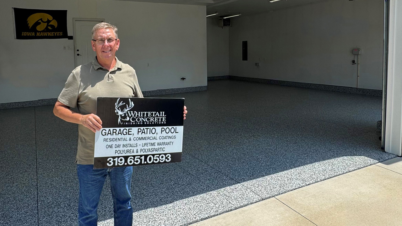 Man holding Whitetail Concrete yard sign outside finished garage